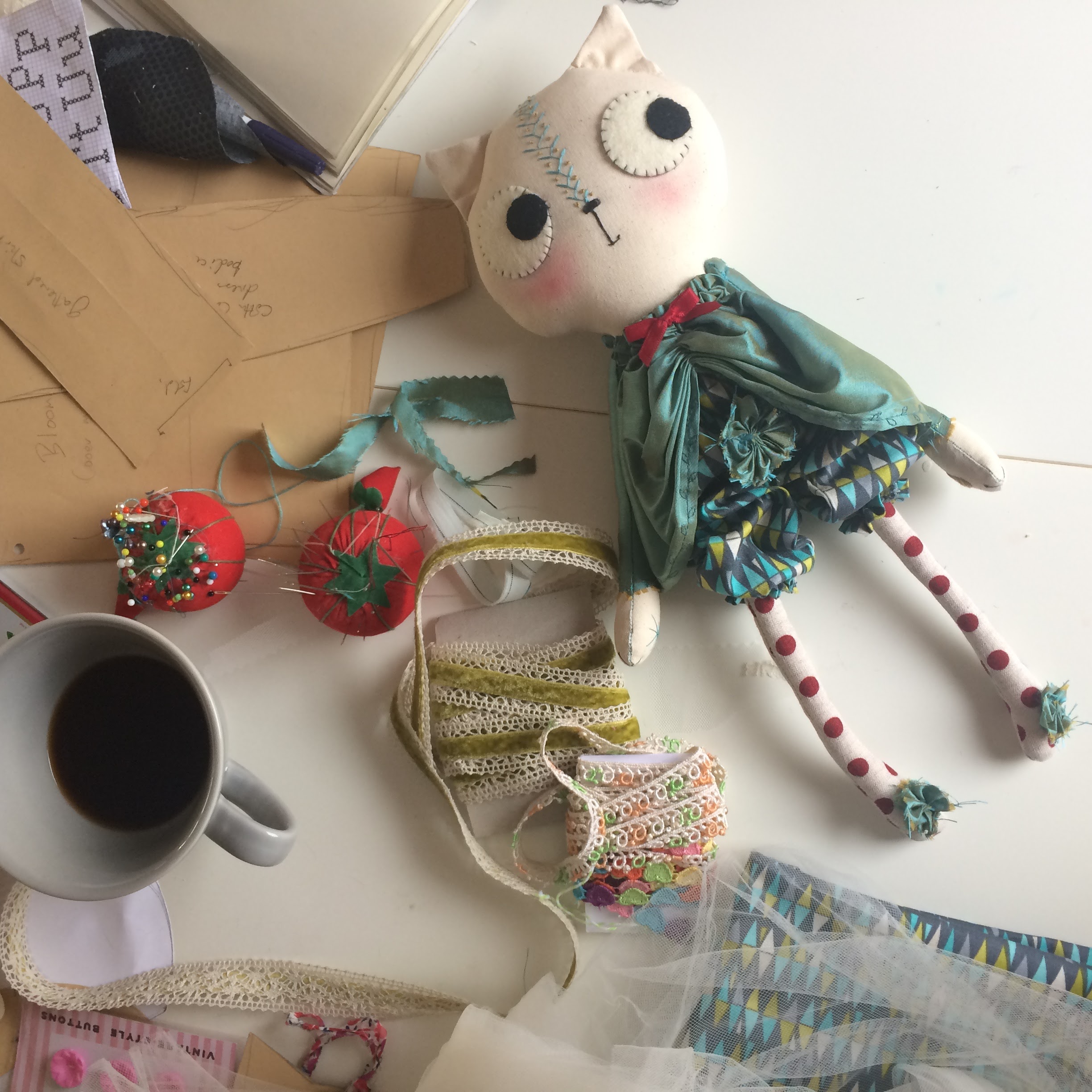 doll on worktable surrounded by fabric trim