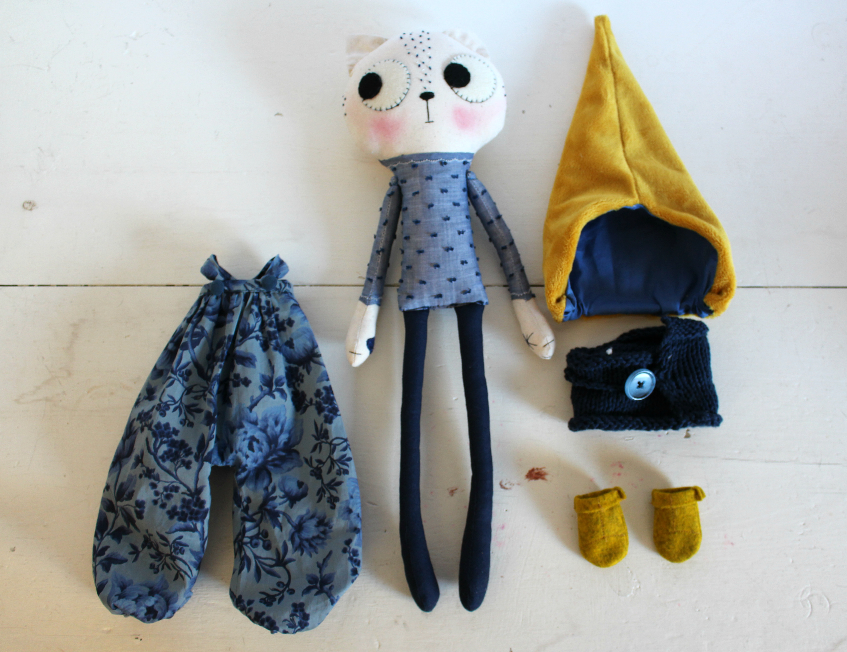 cat doll flat lay with clothes around her