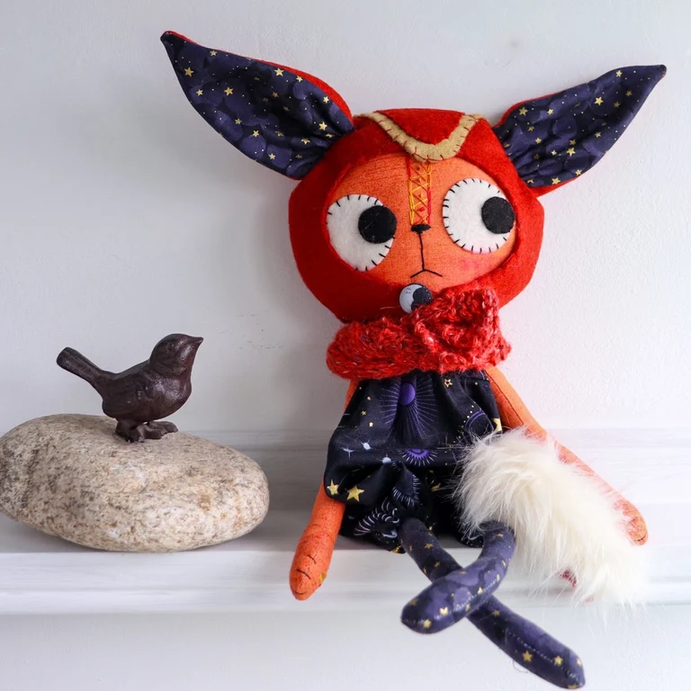 fox doll on a shelf next to an ornamental bronze bird