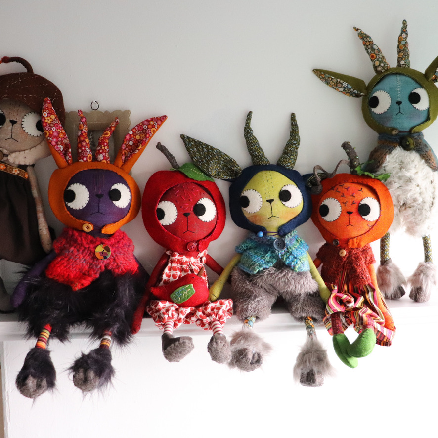 set of dolls with fnacy hats sitting on a shelf